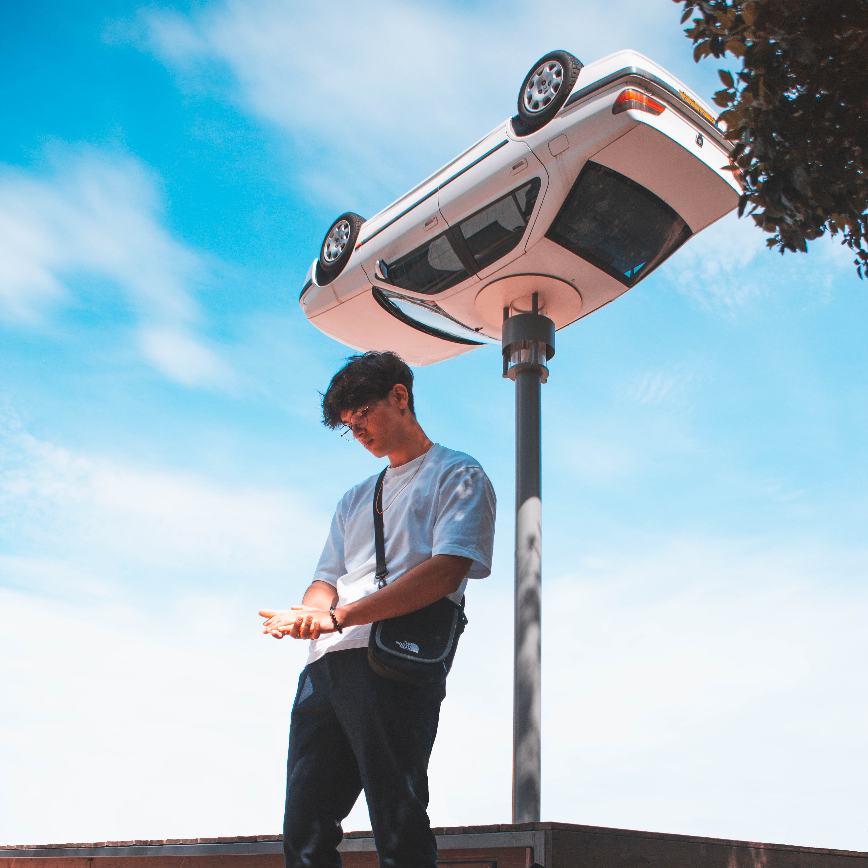 moi debout regardant le sol, avec la peugeot en fond